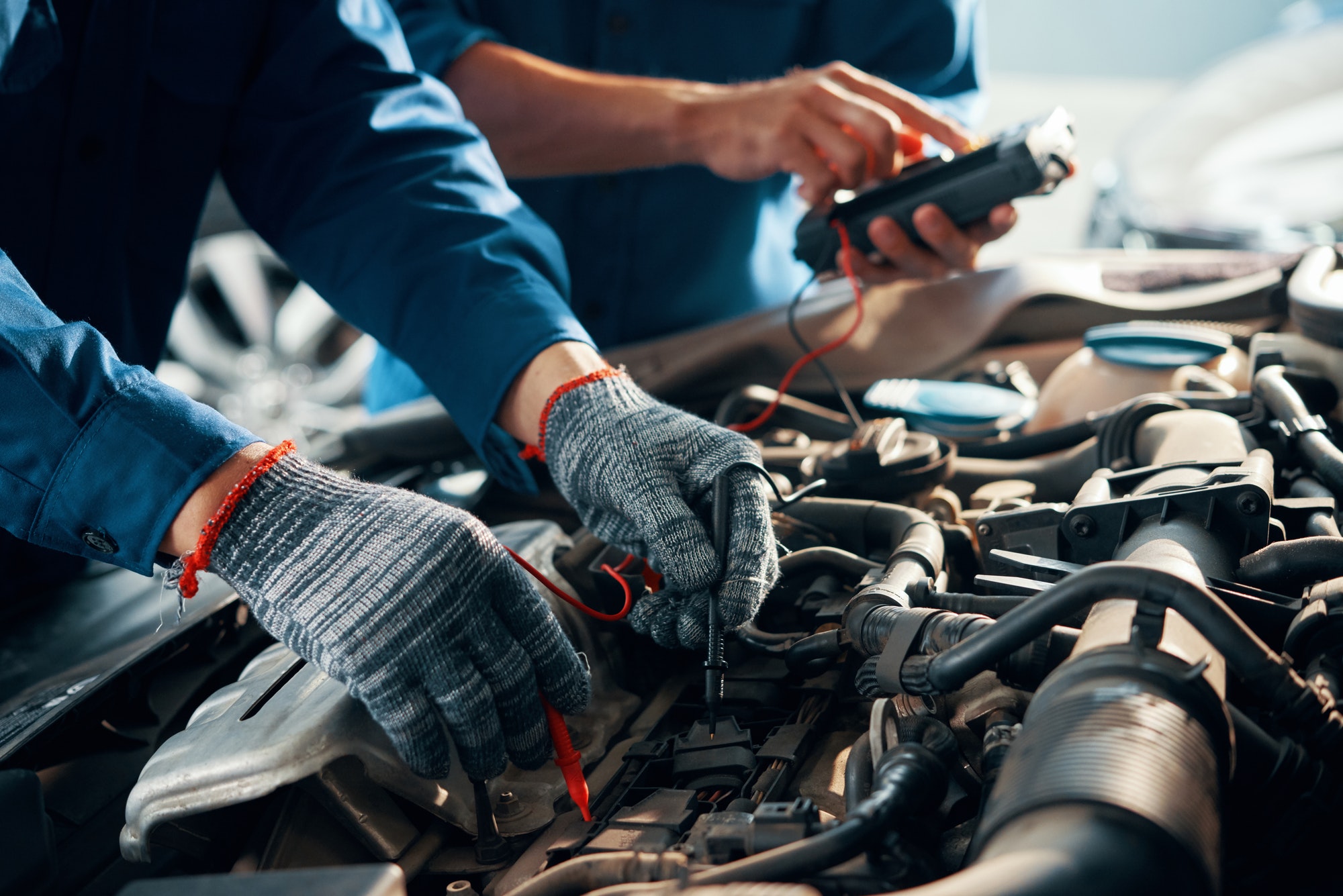 Technician testing a car battery with a meter